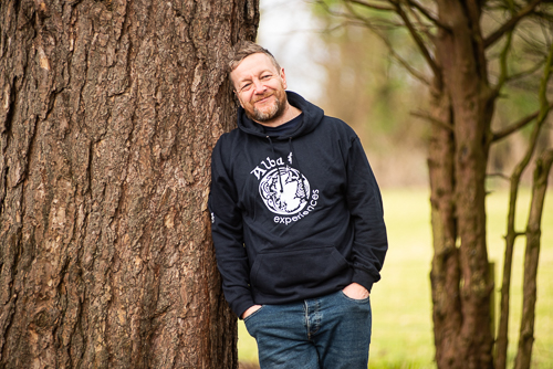a man standing in front of a tree