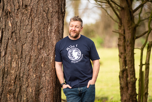 a man standing in front of a tree